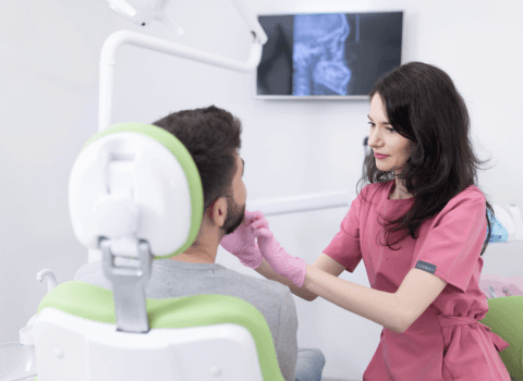 Specialist ortodont care aplica un aparat dentar